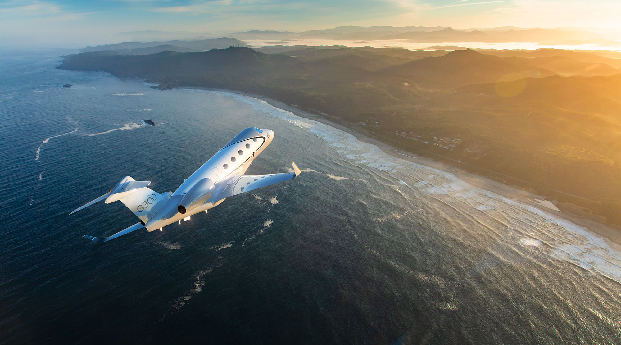 Gulfstream G300 banks to port to follow a hilly shoreline far below, bathed in dawn light.