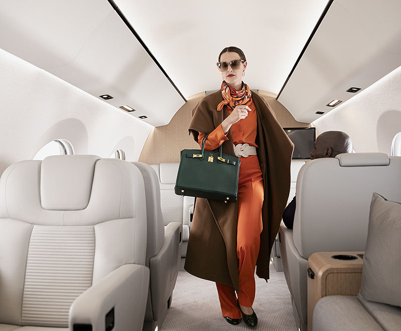 A fashion executive walks down the aisle of a Gulfstream G400 preparing to exit the aircraft