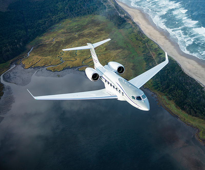 G500 flies over a verdant coastline