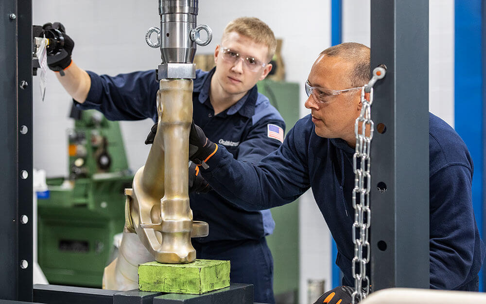 Gulfstream service center employees operate equipment in front of an aircraft being serviced.