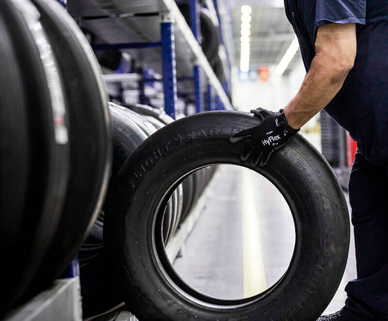 A Gulfstream Customer Support employee pulls an aircraft tire from storage.