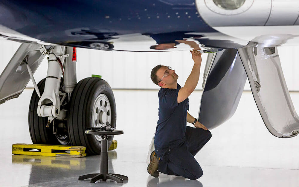 An employee focuses intently on material she is stitching.