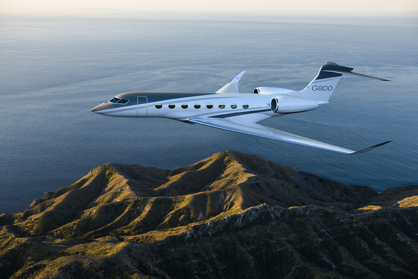 G800 flying over an oceanside mountain range
