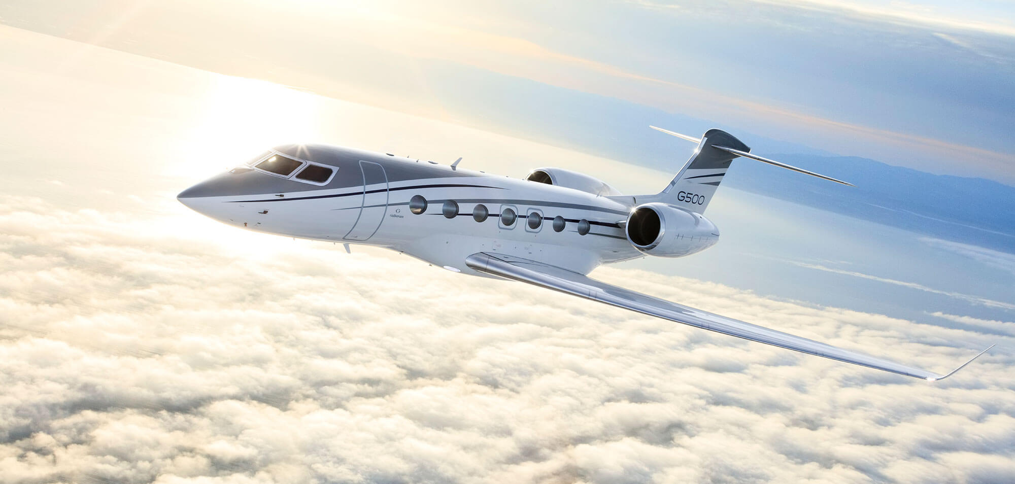 Parallel to a slightly tilted horizon, a Gulfstream G500 speeds above a field of clouds.