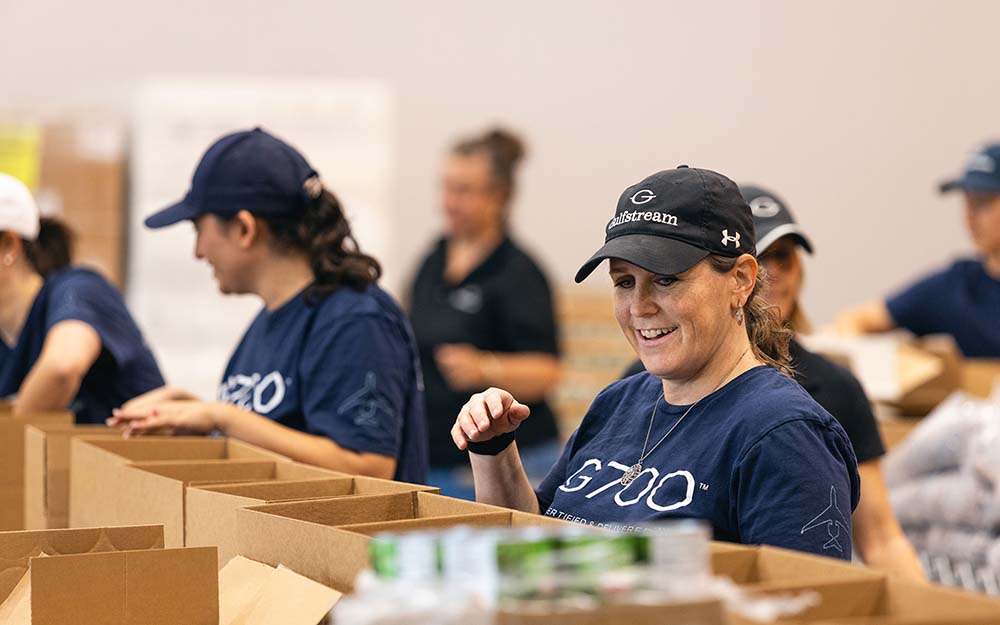 Employees volunteer filling grocery bags at Savannah's Second Harvest food pantry.