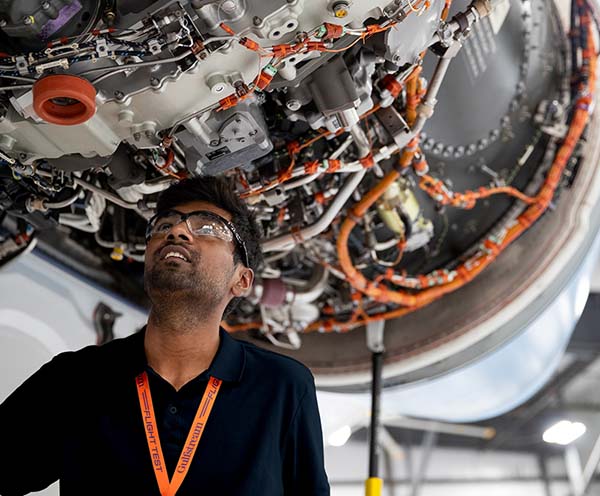 A Gulfstream employee inspects an engine in a service hangar.