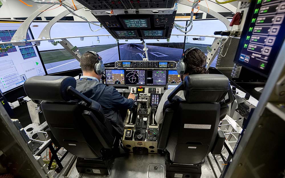 Engineers work in the flight deck of Gulfstream's Iron Bird flight-simulation rig.