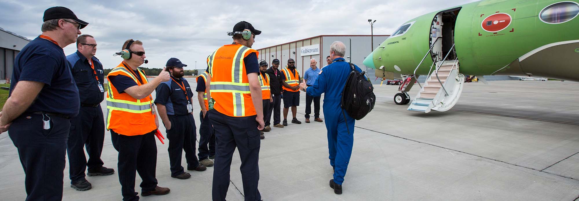 Gulfstream Test Flight employees greet a test pilot as he boards a test Gulfstream G500.