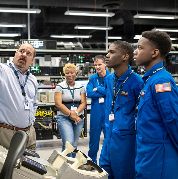 Gulfstream employees demonstrate aviation concepts to uniformed students particpating in the company's Pilot For a Day program.
