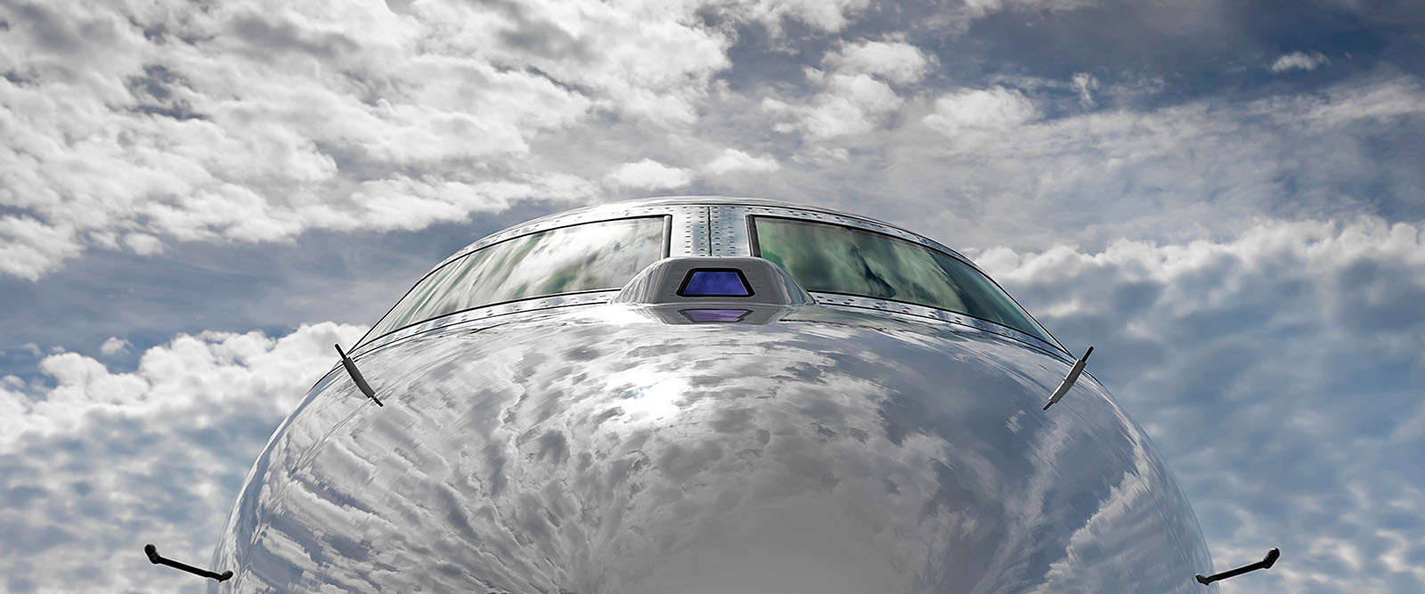 View of Gulfstream aircraft from the nose reflecting blue sky and clouds